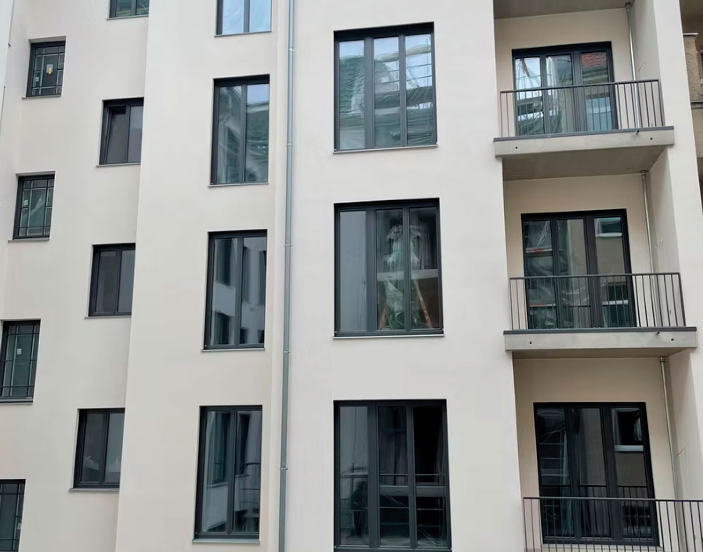 Helle Gebäudefassade mit Fenstern – Essener Str. 23