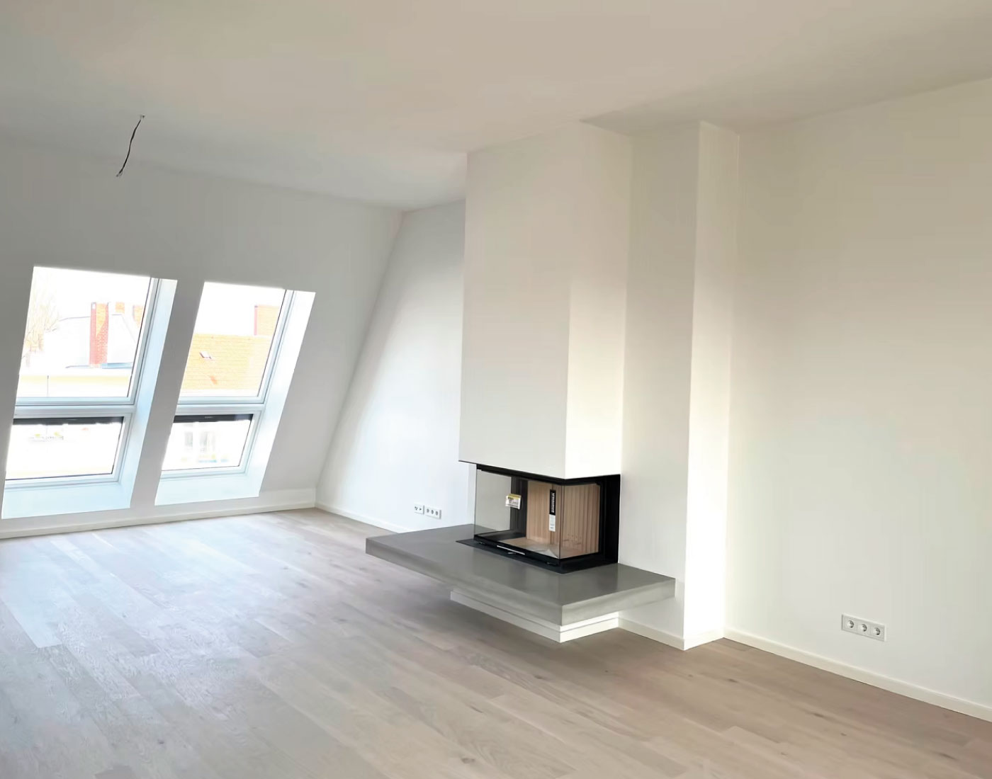 Heller Innenraum mit Kamin und Holzfußboden – Essener Str. 23