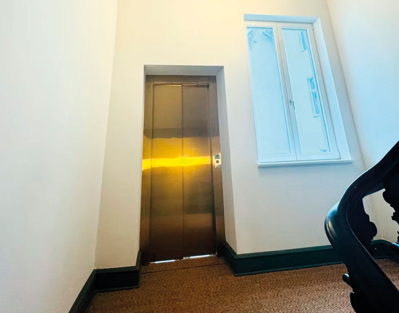 Aufzugstür neben einem Fenster und Treppengeländer – Grolmanstraße 52