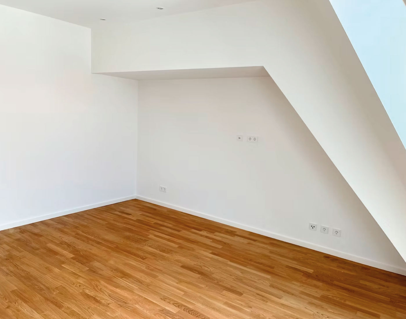 Heller Innenraum mit Holzfußboden und weißen Wandflächen – Riehlstraße 13