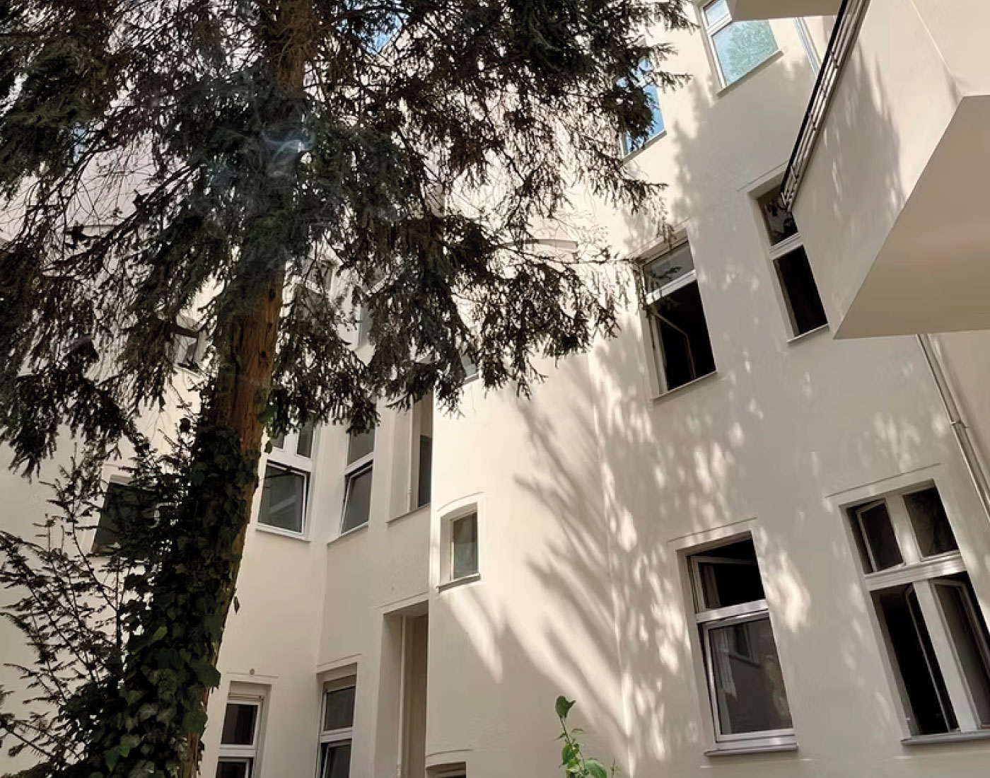 Helle Gebäudefassade mit Fenstern – Stubenrauchstraße 8