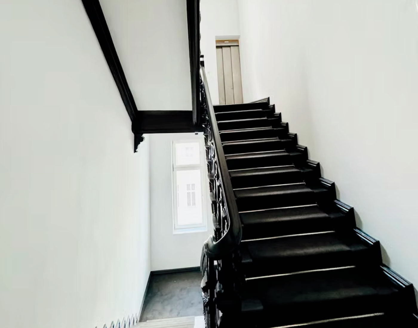 Treppenaufgang mit hellen Wandflächen – Uhlandstraße 28